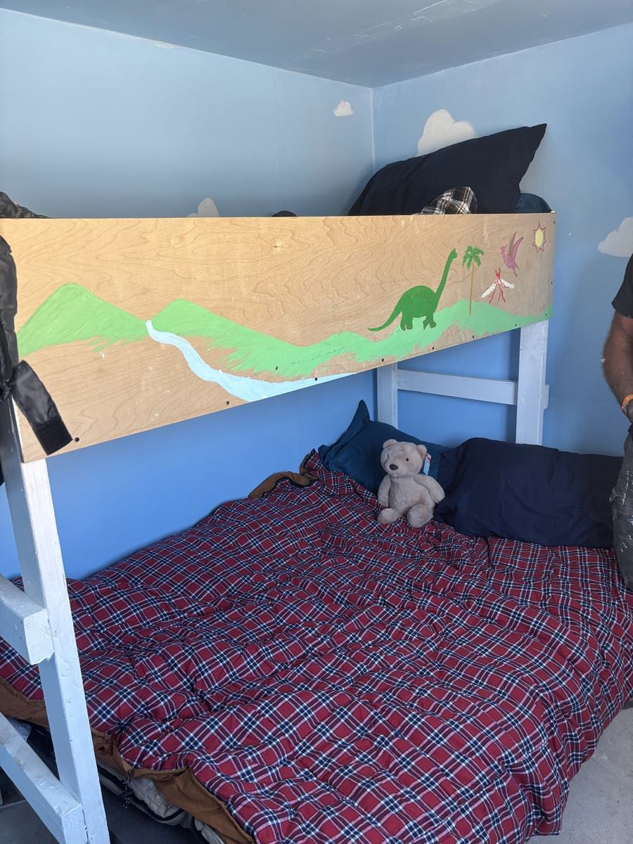 A child's new bunk bed with a teddy bear inside a finished Club Dust home