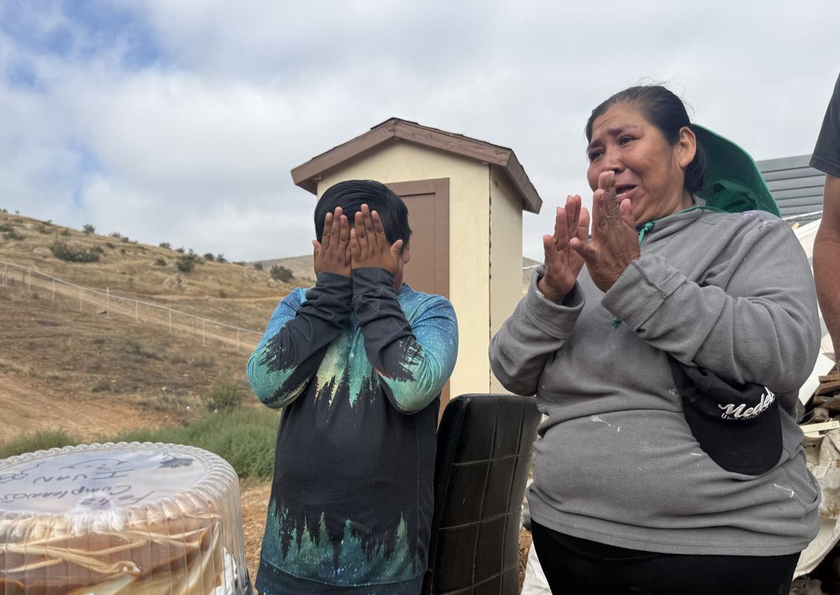 A mother and son overcome with emotion at their home dedication