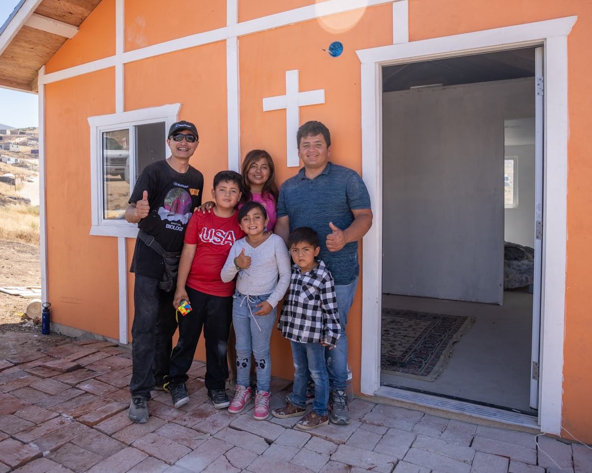 A Tecate family standing in the doorway of their newly finished home
