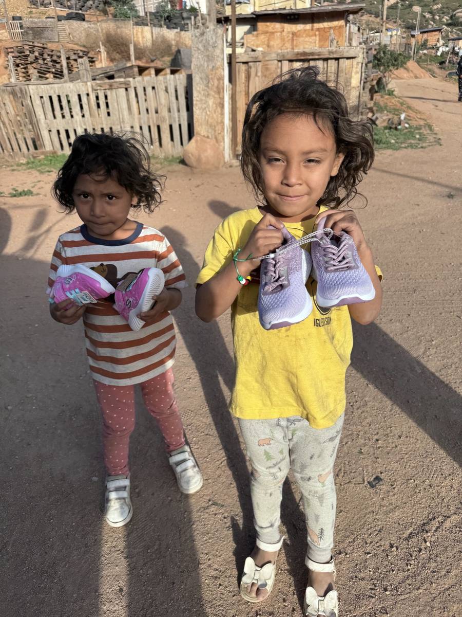 Two Tecate children holding new shoes