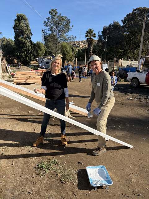 Volunteers carrying trim boards across the site
