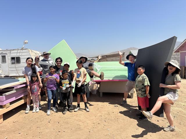 Kids gathered under roofing panels for shade