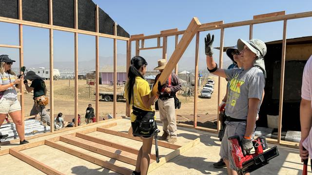 A framing crew waving from the build