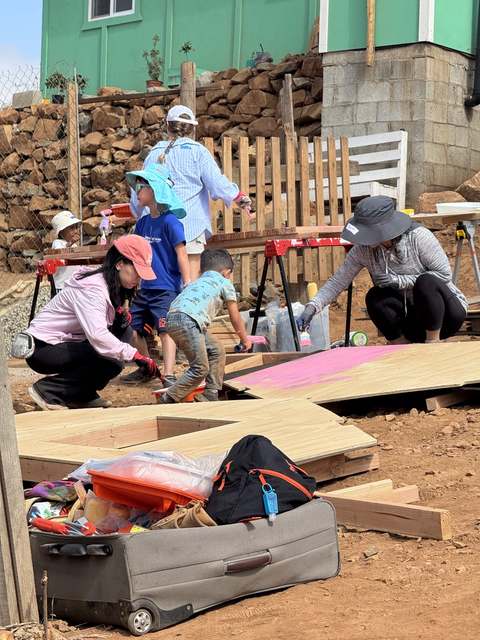Kids helping paint panels pink