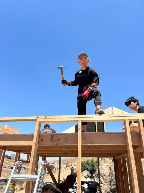 A young volunteer hammering against the sky