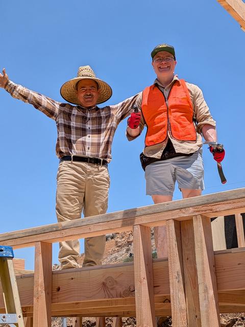 Two builders celebrating with arms raised