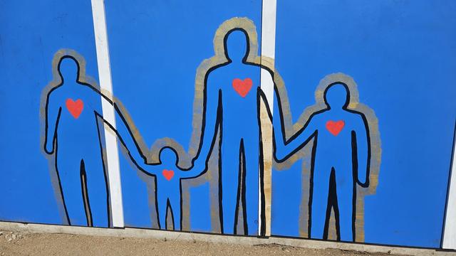 A family mural painted on a blue home