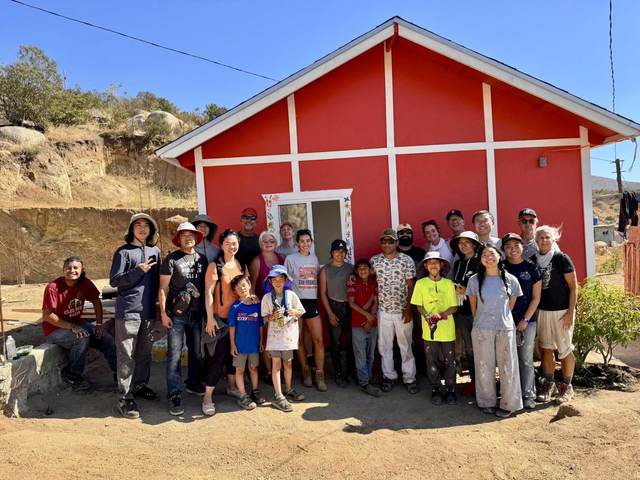 The crew gathered at a red home