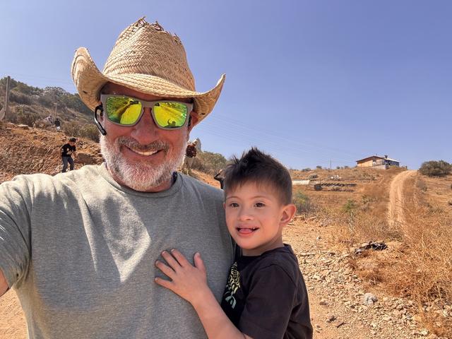 A volunteer and a boy in a straw hat